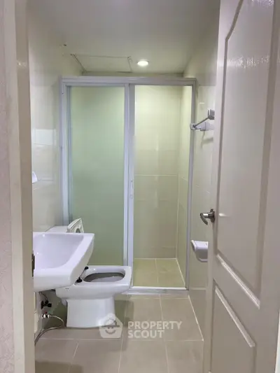 Compact bathroom with modern fixtures and sliding glass shower door