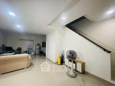 Spacious living room with modern decor and staircase, ideal for family gatherings.