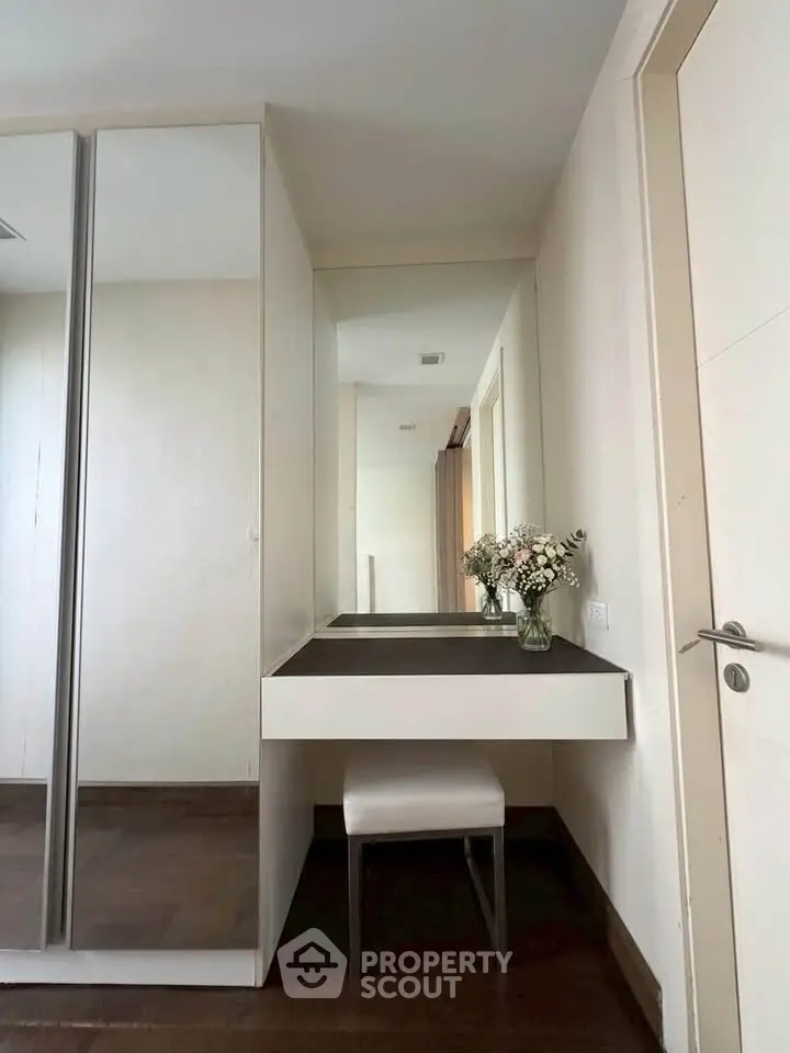 Elegant bedroom corner with mirrored wardrobe and stylish vanity table.