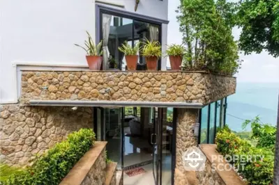 Stunning stone facade house with ocean view and lush greenery