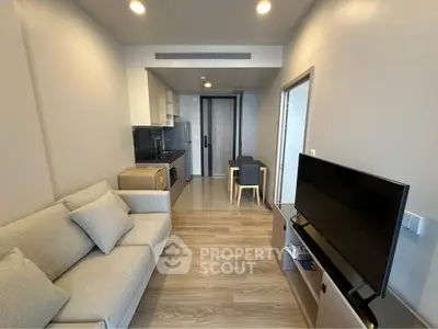 Modern living room with sleek furniture and open kitchen layout in a stylish apartment.