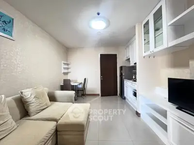 Modern living room with cozy sofa and integrated kitchen in open layout apartment.