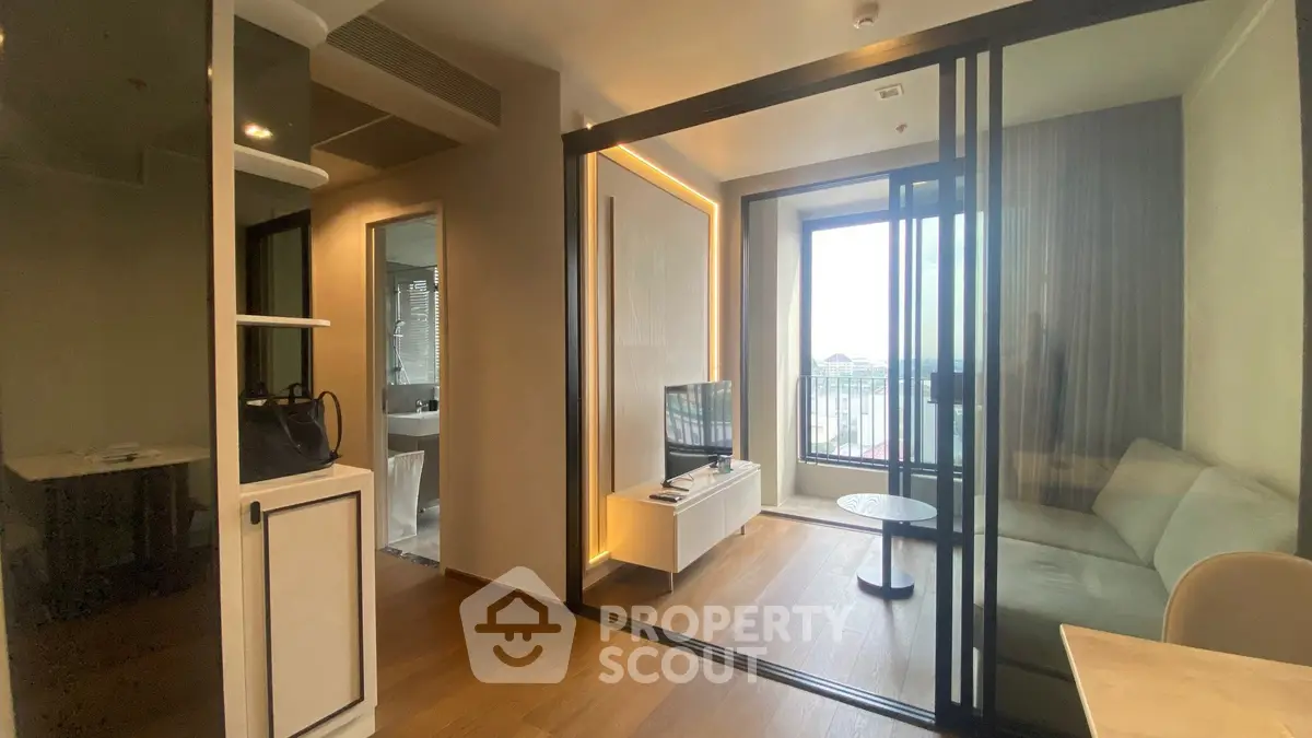 Modern living room with glass partition and balcony view in stylish apartment.