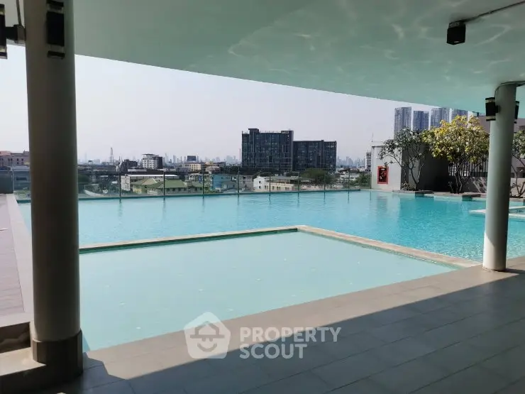 Luxurious rooftop pool with stunning city skyline views in modern apartment complex.