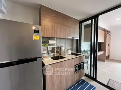 Modern kitchen with sleek cabinetry and stainless steel appliances in a stylish apartment.
