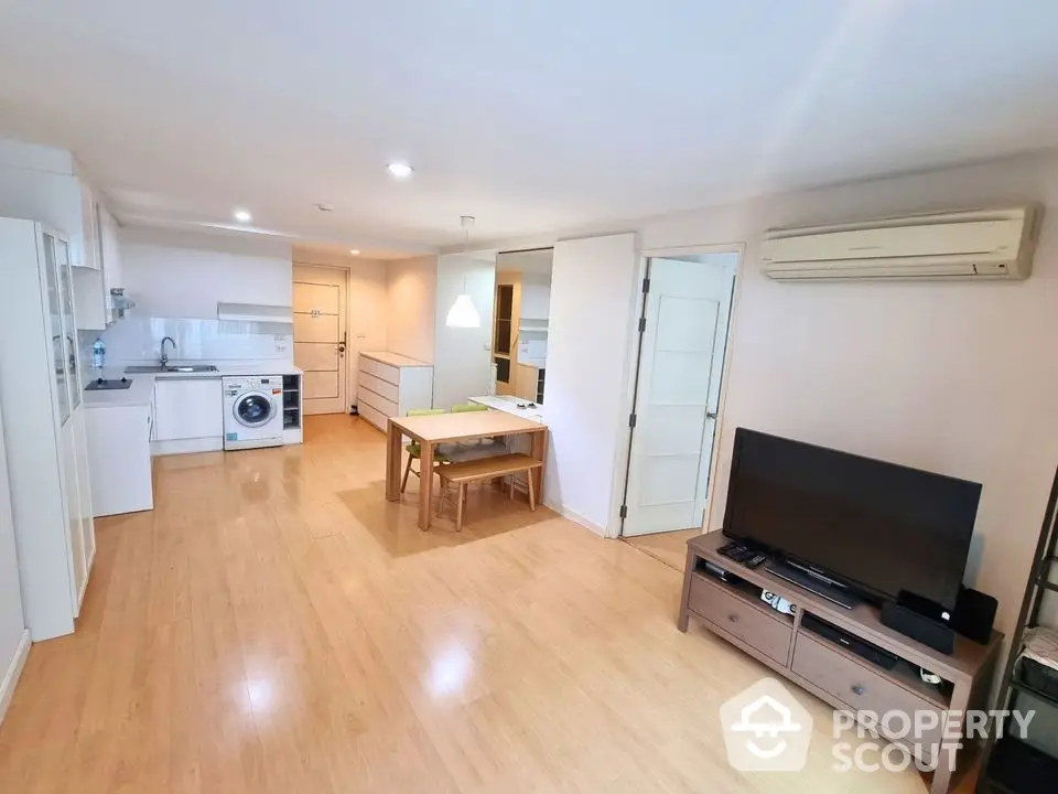 Spacious open-plan living room with modern kitchen and wooden flooring