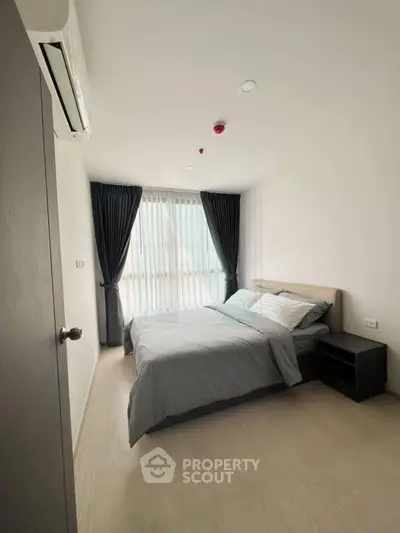 Modern bedroom with natural light and stylish decor in a contemporary apartment.