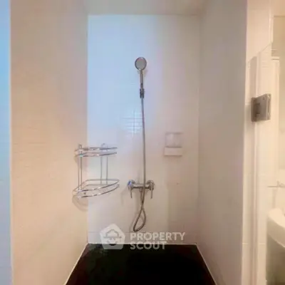 Modern minimalist bathroom with sleek shower design and white tile walls.