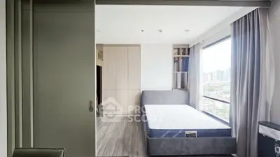 Modern bedroom with large window offering city view and sleek furnishings.