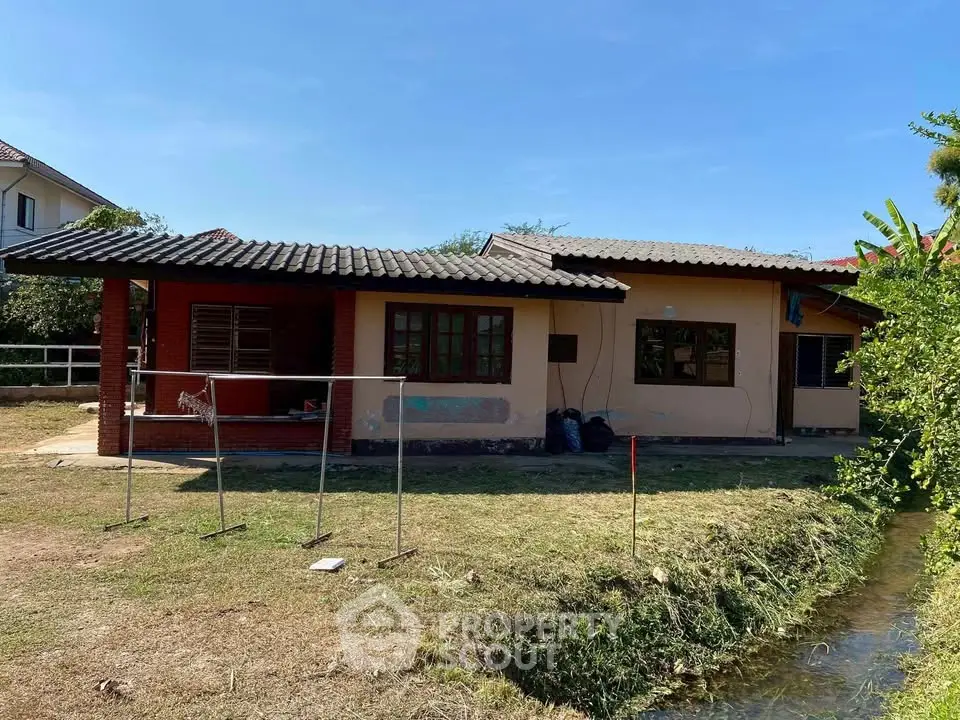 Charming single-story house with rustic appeal and spacious yard by a serene stream.