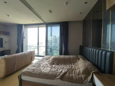 Luxurious bedroom with city view and modern furnishings in high-rise apartment.
