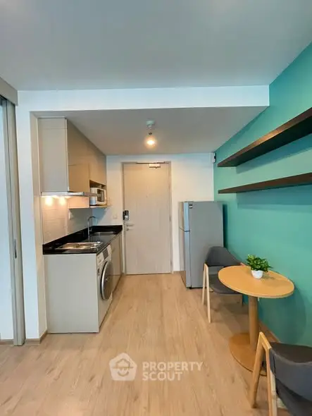 Modern compact kitchen with washing machine and dining area in stylish apartment