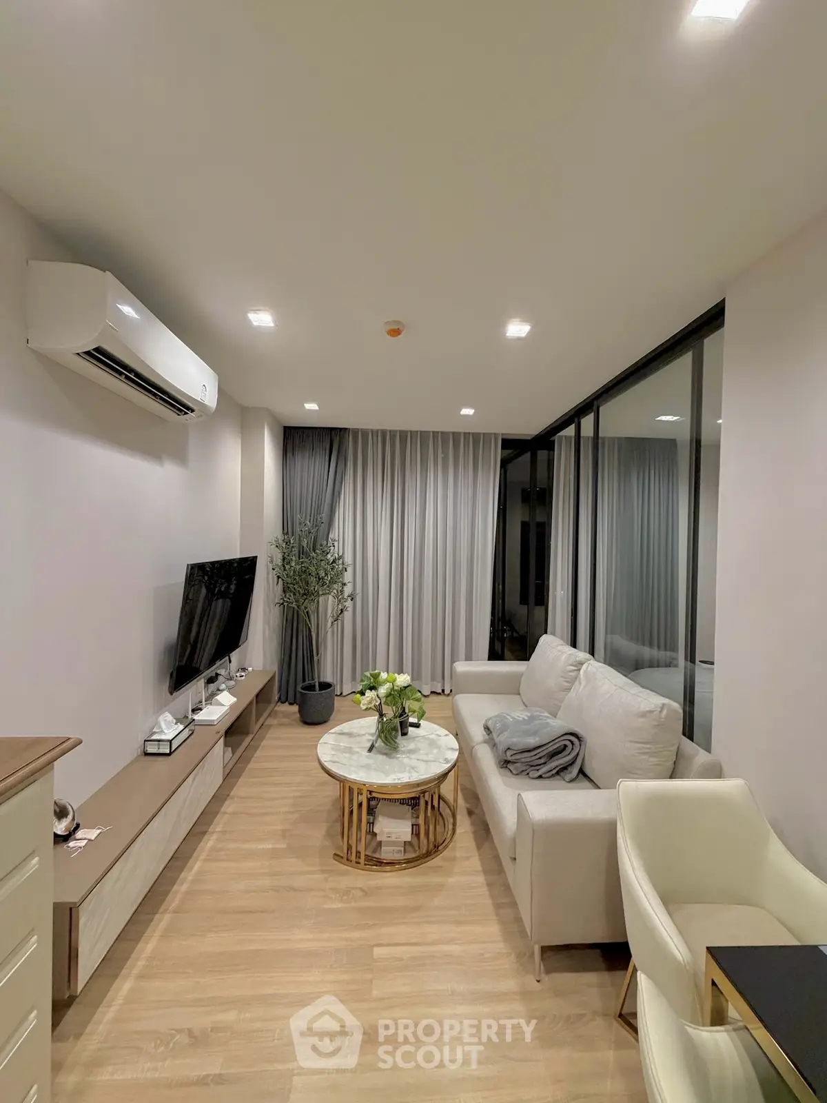 Modern living room with sleek design, featuring a cozy sofa, stylish TV setup, and elegant decor.