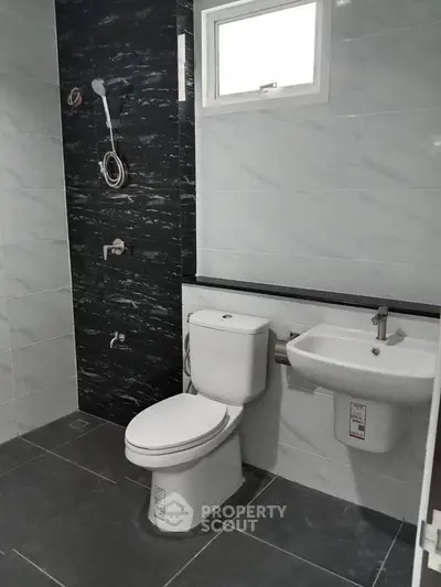 Modern bathroom with sleek fixtures and stylish black accent wall