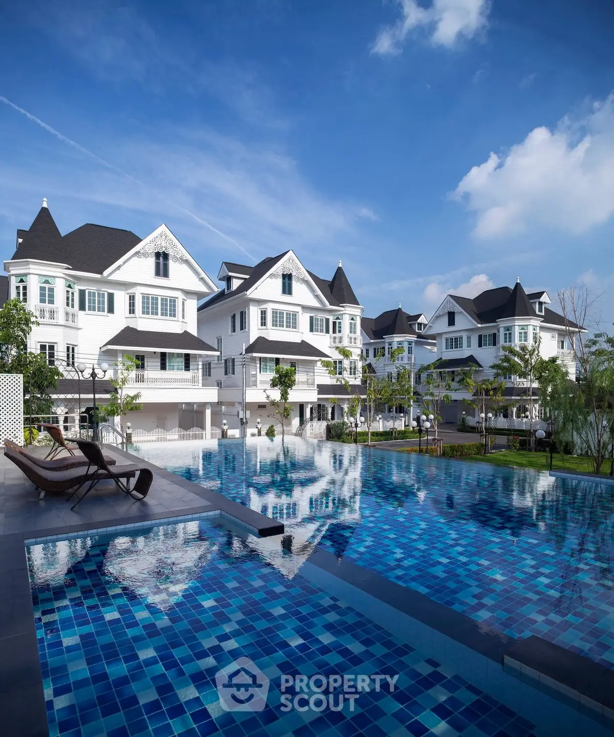 Luxurious residential villas with a stunning outdoor pool and serene garden view.