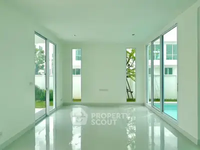 Bright and spacious modern living room with large windows and garden view