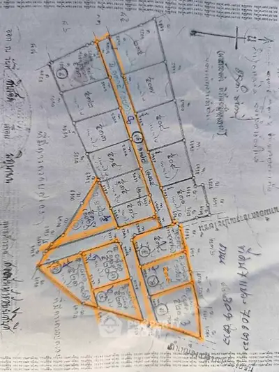 Hand-drawn real estate plot map with numbered lots and street layout.