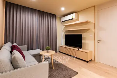 Modern living room with stylish furniture and sleek design, featuring a cozy sofa and entertainment center.