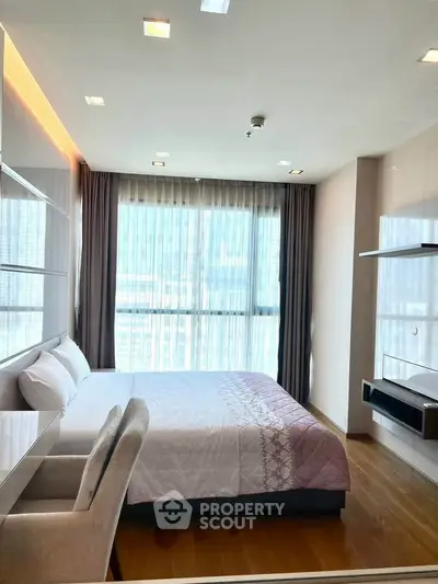 Modern bedroom with large window and elegant decor, featuring a comfortable bed and stylish furnishings.