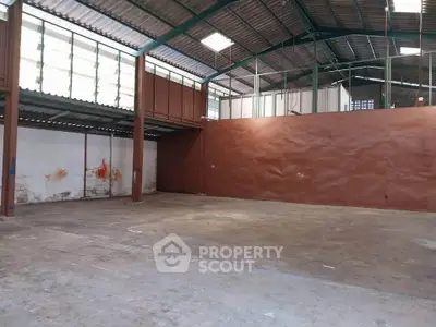 Spacious industrial warehouse with high ceilings and ample natural light.