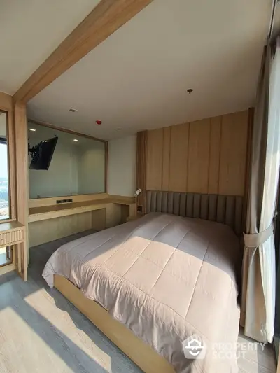 Spacious bedroom with modern wooden paneling and ample natural light, featuring a large bed, elegant furnishings, and a serene ambiance perfect for relaxation.