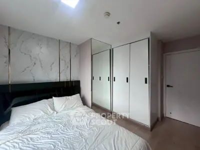 Modern bedroom with sleek mirrored wardrobe and cozy bedding