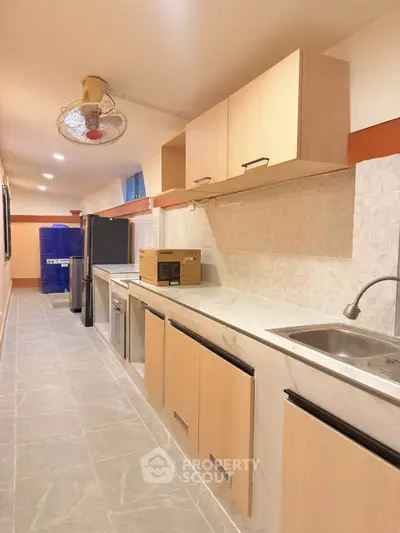 Spacious kitchen with modern appliances and sleek cabinetry in a well-lit interior.