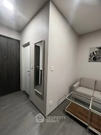 Modern living room with sleek design, featuring a cozy sofa, glass coffee table, and stylish wall art.