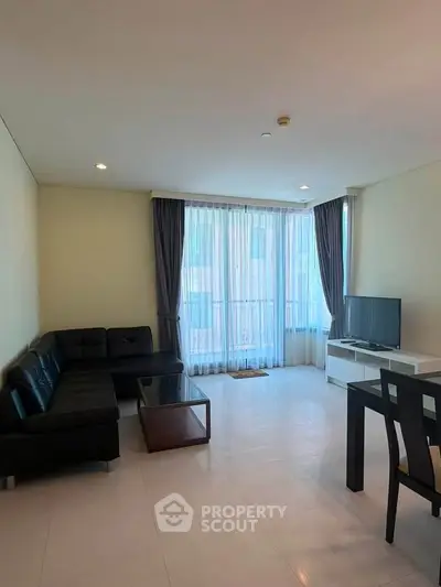 Spacious living room with modern furniture and large windows in a stylish apartment.
