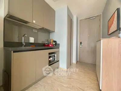 Modern compact kitchen with sleek cabinetry and integrated appliances in a stylish apartment.
