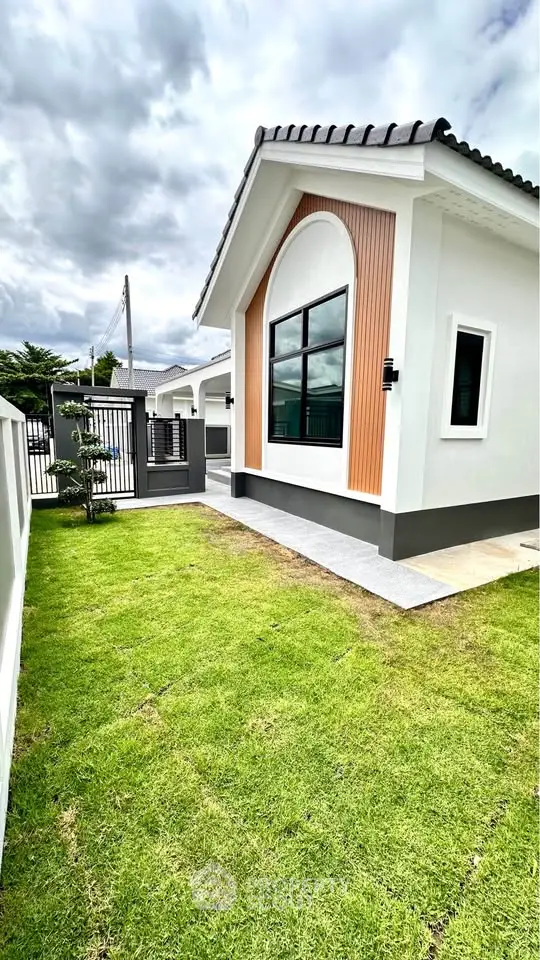 Charming modern house exterior with lush green lawn and stylish architectural design.