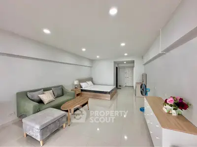 Spacious studio apartment with modern furnishings and bright lighting