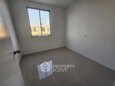 Minimalist empty room with large window and tiled floor, perfect for customization.