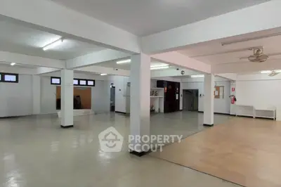 Spacious open-plan interior with ample natural light, ideal for versatile use in real estate.