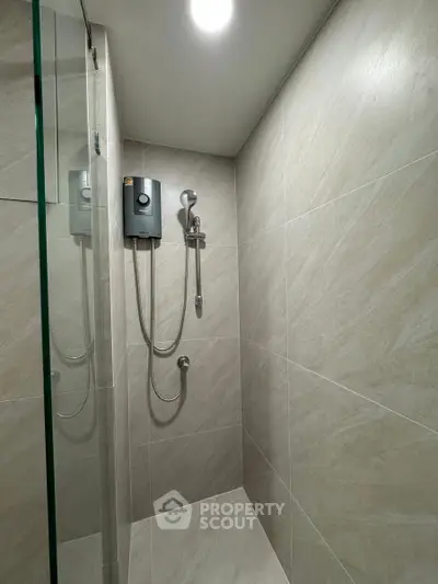 Modern bathroom shower area with sleek tiles and glass partition