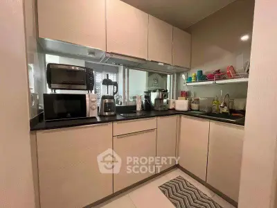 Modern kitchen with sleek cabinetry and appliances in compact layout