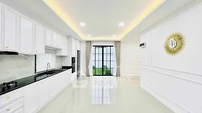 Spacious modern kitchen with sleek white cabinetry and large window view.