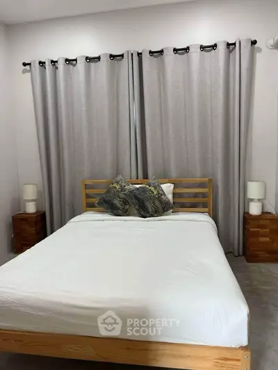 Cozy bedroom with modern wooden bed and elegant curtains, perfect for relaxation.