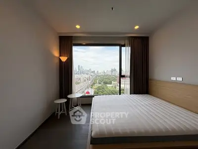 Modern bedroom with large window offering stunning city view