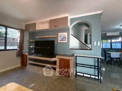 Spacious living room with modern decor and large TV setup