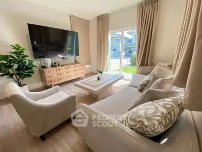 Elegant living room with modern decor, large TV, and natural light from glass doors.