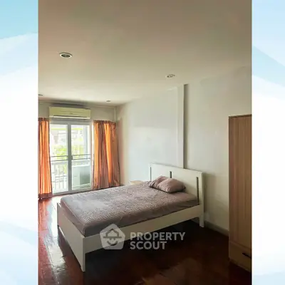 Spacious bedroom with natural light and balcony access in modern apartment.