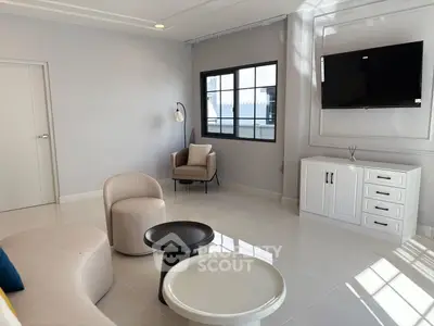Modern living room with sleek furniture and large window, offering a bright and inviting atmosphere.