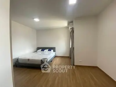Spacious bedroom with wooden flooring and modern bed frame