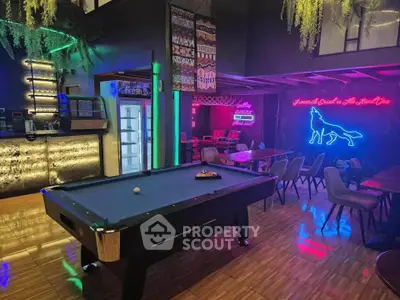 Stylish game room with pool table and neon lights, perfect for entertainment.