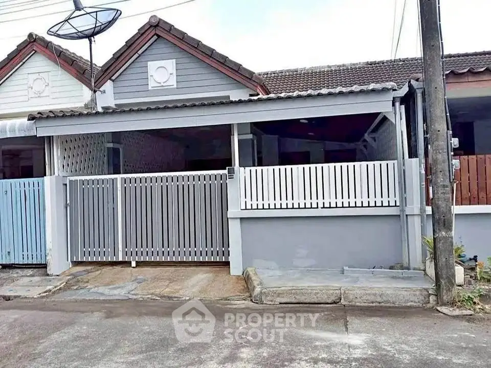 Charming single-story home with gated entrance and satellite dish, perfect for cozy living.
