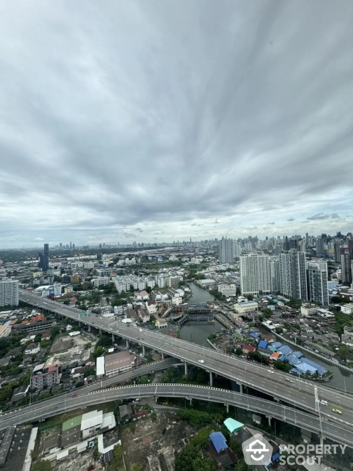 Stunning cityscape view from a high-rise building showcasing expansive urban skyline and highway network.