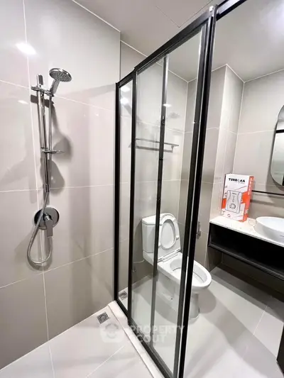 Modern bathroom with glass shower enclosure and sleek fixtures.