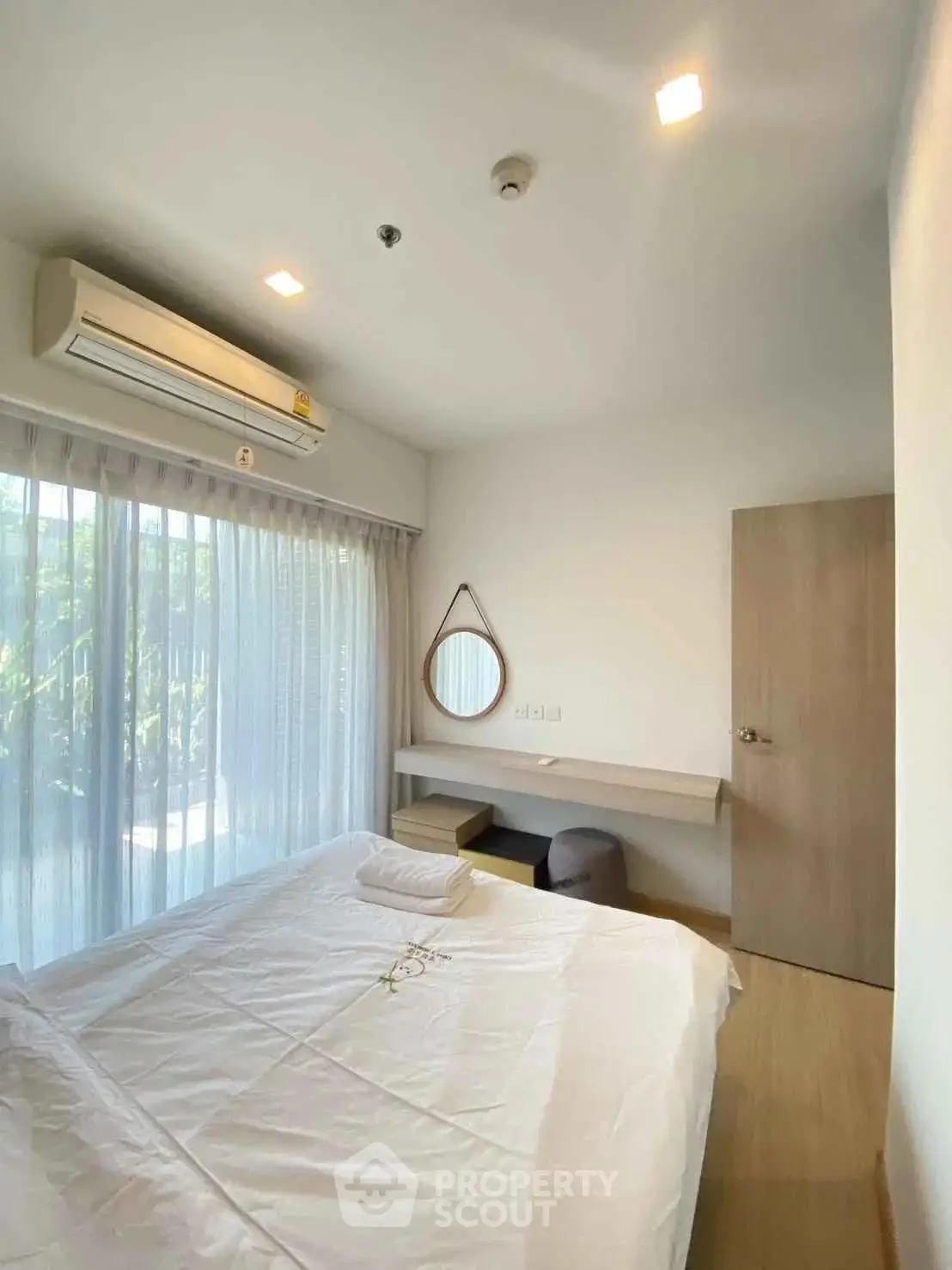 Bright and cozy bedroom with large window and modern decor
