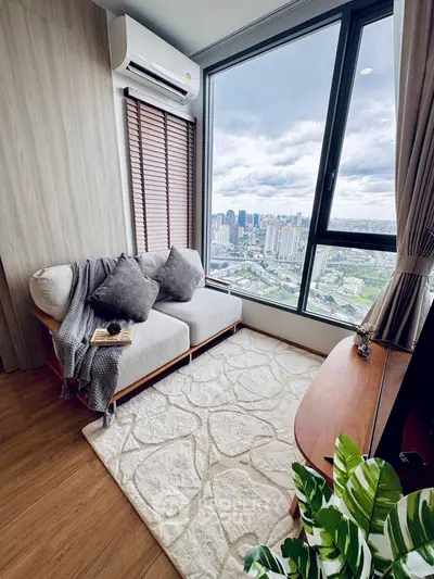 Modern living room with stunning city view, cozy seating, and elegant decor.